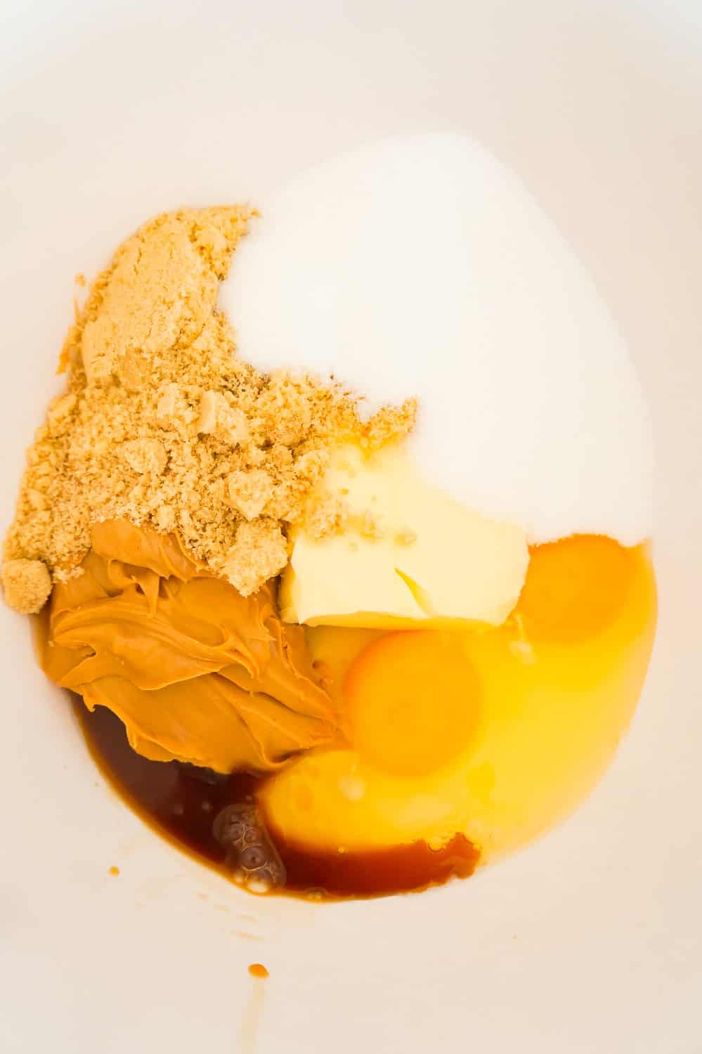 eggs, peanut butter sugar, brown sugar and vanilla extract in a mixing bowl