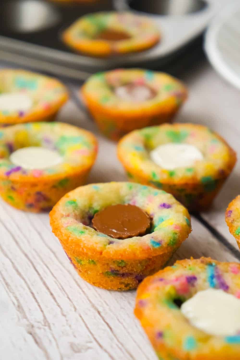 Peanut Butter Cup Sugar Cookies are a cute and colourful dessert perfect for spring. These sugar cookie cups are made in mini muffin tins and contain mini Reese's peanut butter cups and white chocolate peanut butter cups.