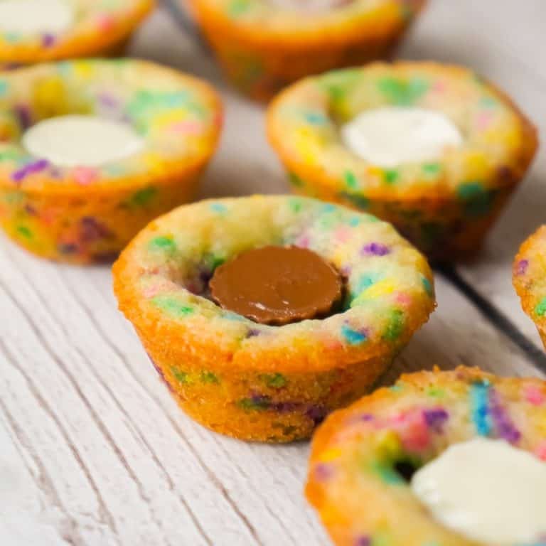 Peanut Butter Cup Sugar Cookies are a cute and colourful dessert perfect for spring. These sugar cookie cups are made in mini muffin tins and contain mini Reese's peanut butter cups and white chocolate peanut butter cups.