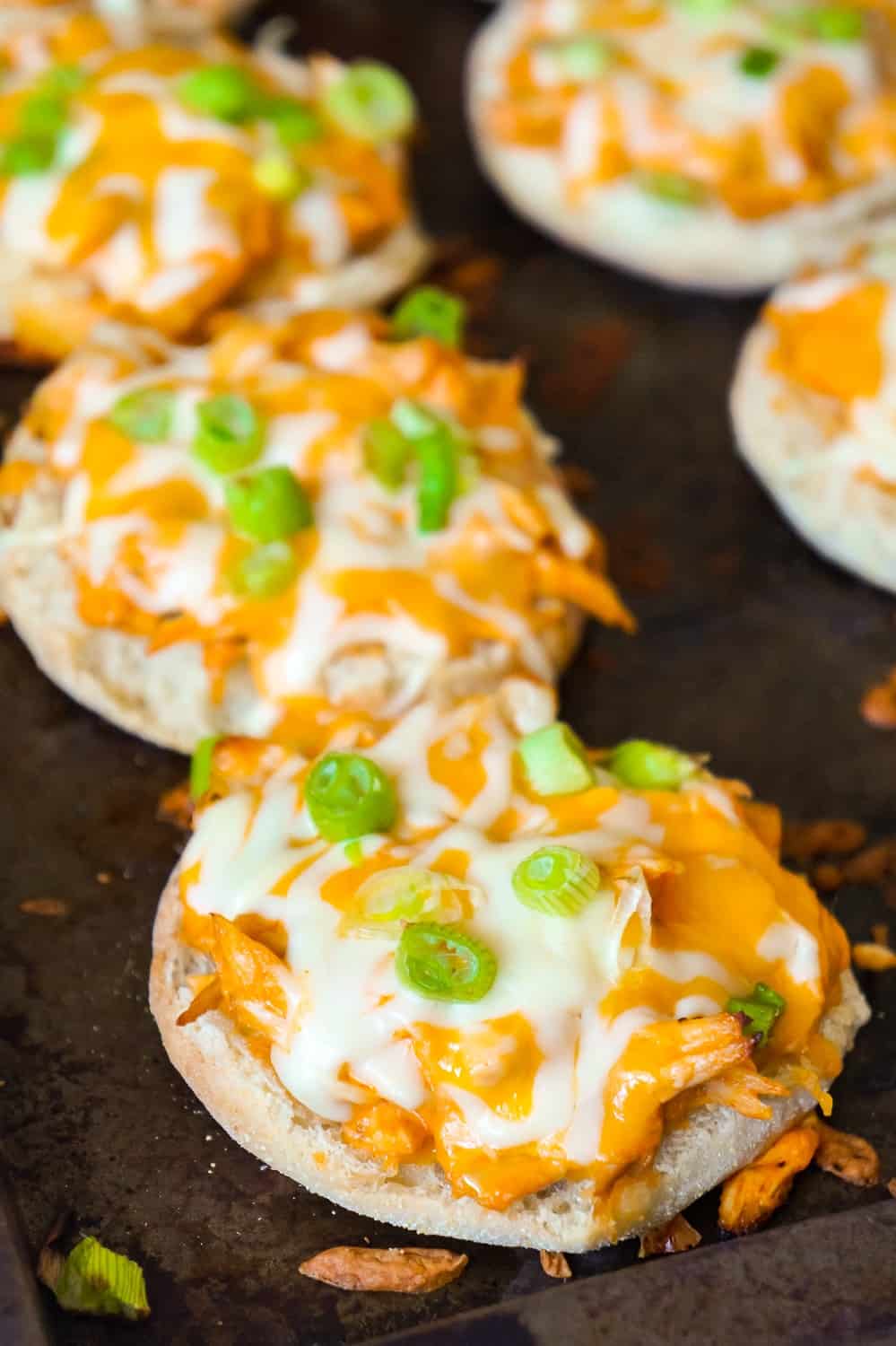 Buffalo Chicken English Muffins are an easy weeknight dinner recipe using rotisserie chicken. These English muffins are topped with shredded chicken tossed in Buffalo sauce and baked with cheese on top.