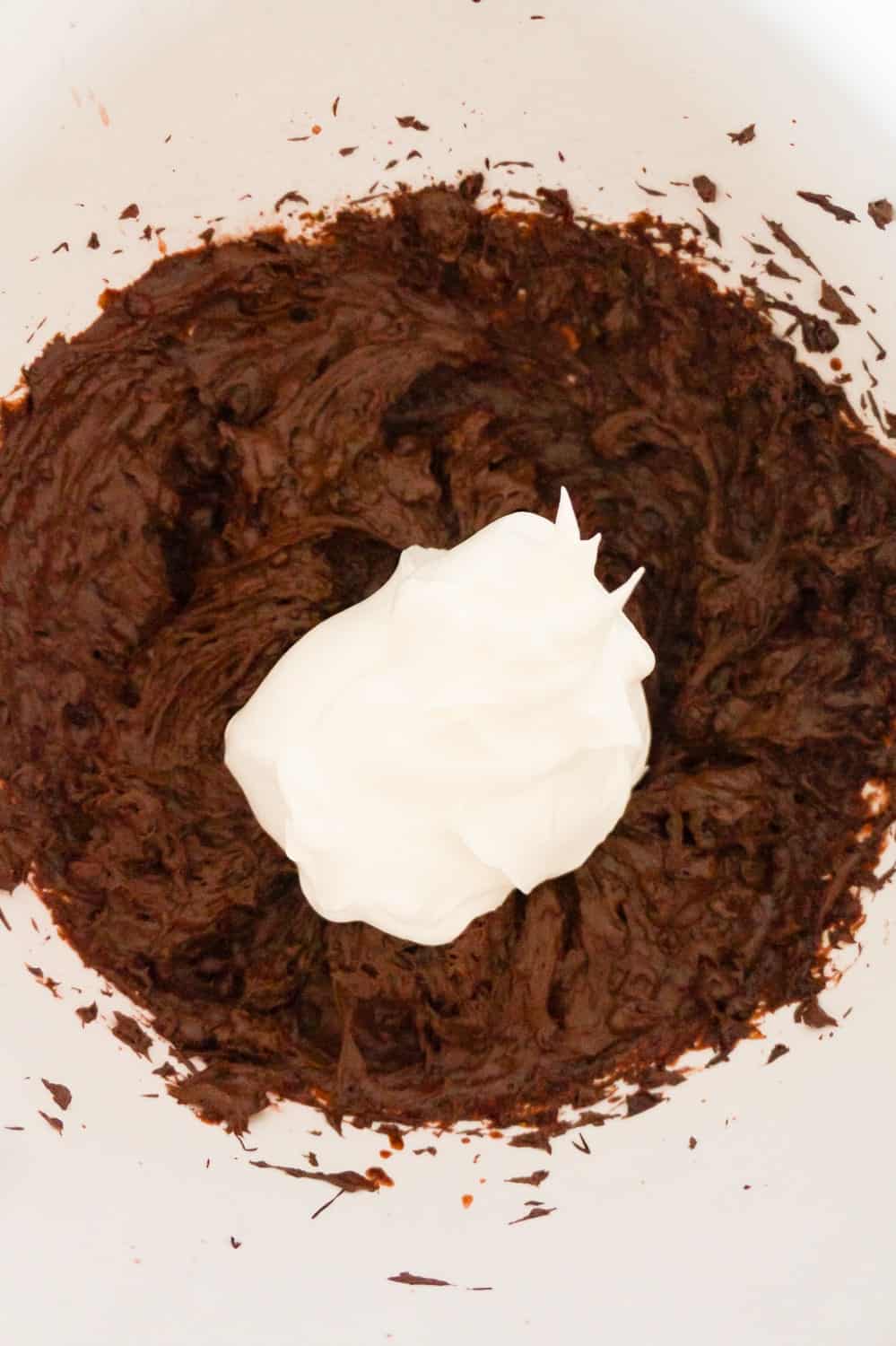 chocolate pudding mixture with Cool Whip on top in a mixing bowl