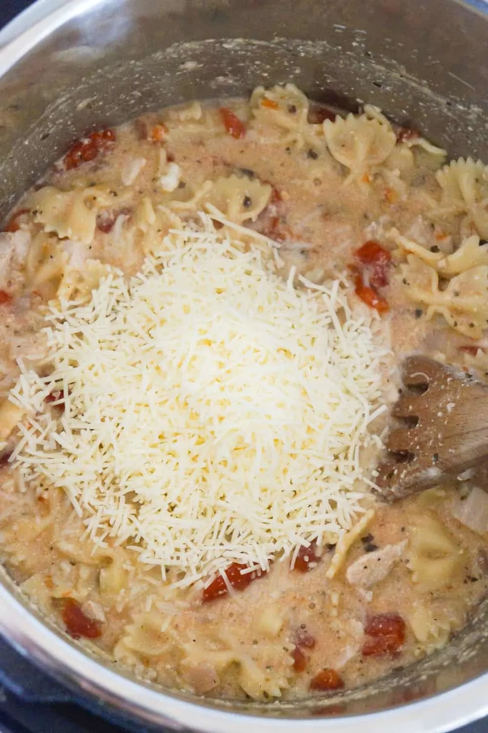 Shredded cheese on top of bruschetta chicken pasta in an Instant Pot