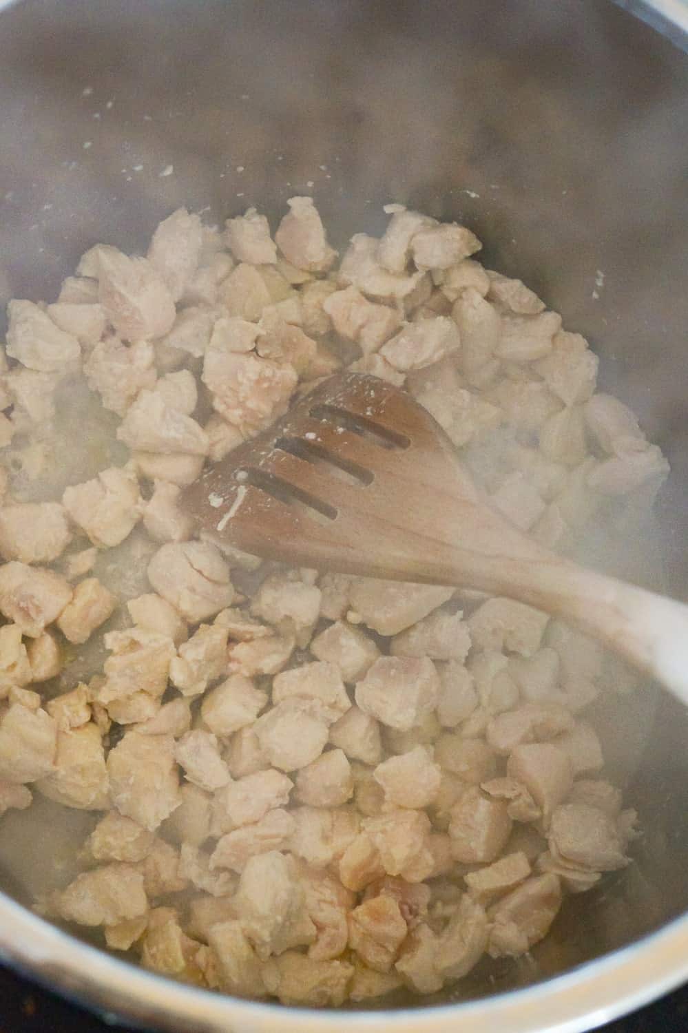 small chunks of chicken breast cooking in an Instant Pot