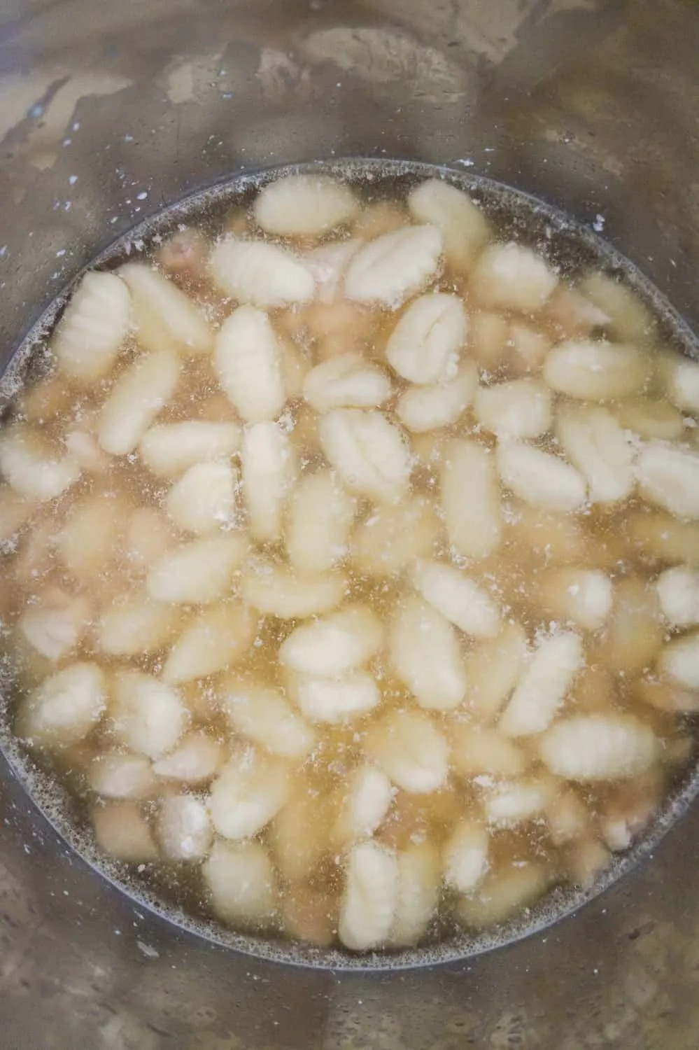 uncooked potato gnocchi in chicken broth in an Instant Pot