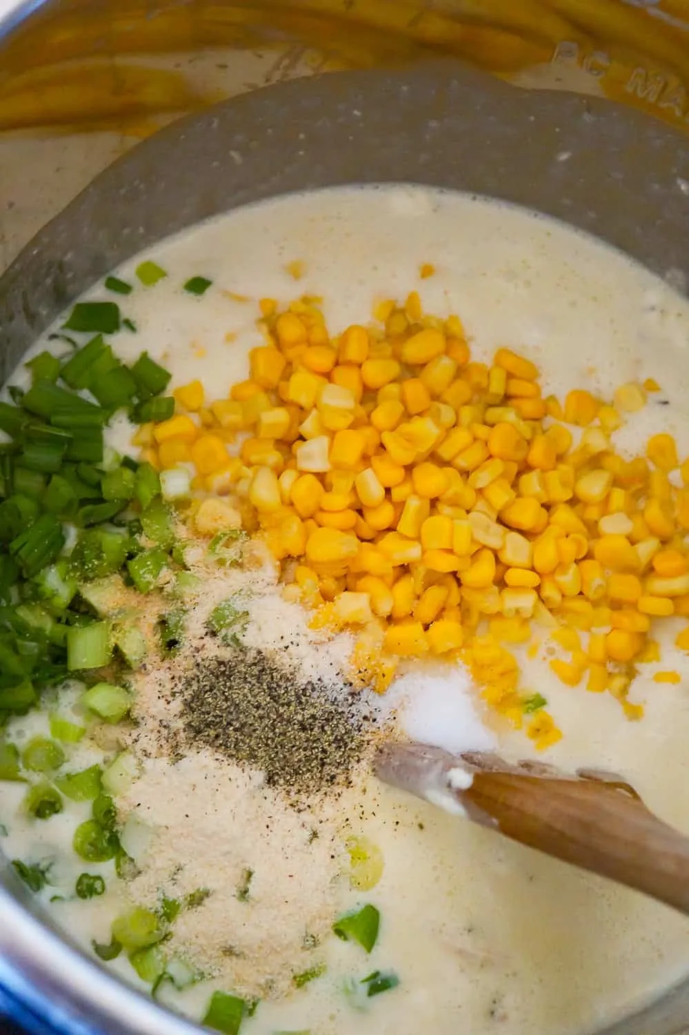 corn, chopped green onions, pepper and garlic powder on top of creamy mixture in an Instant Pot