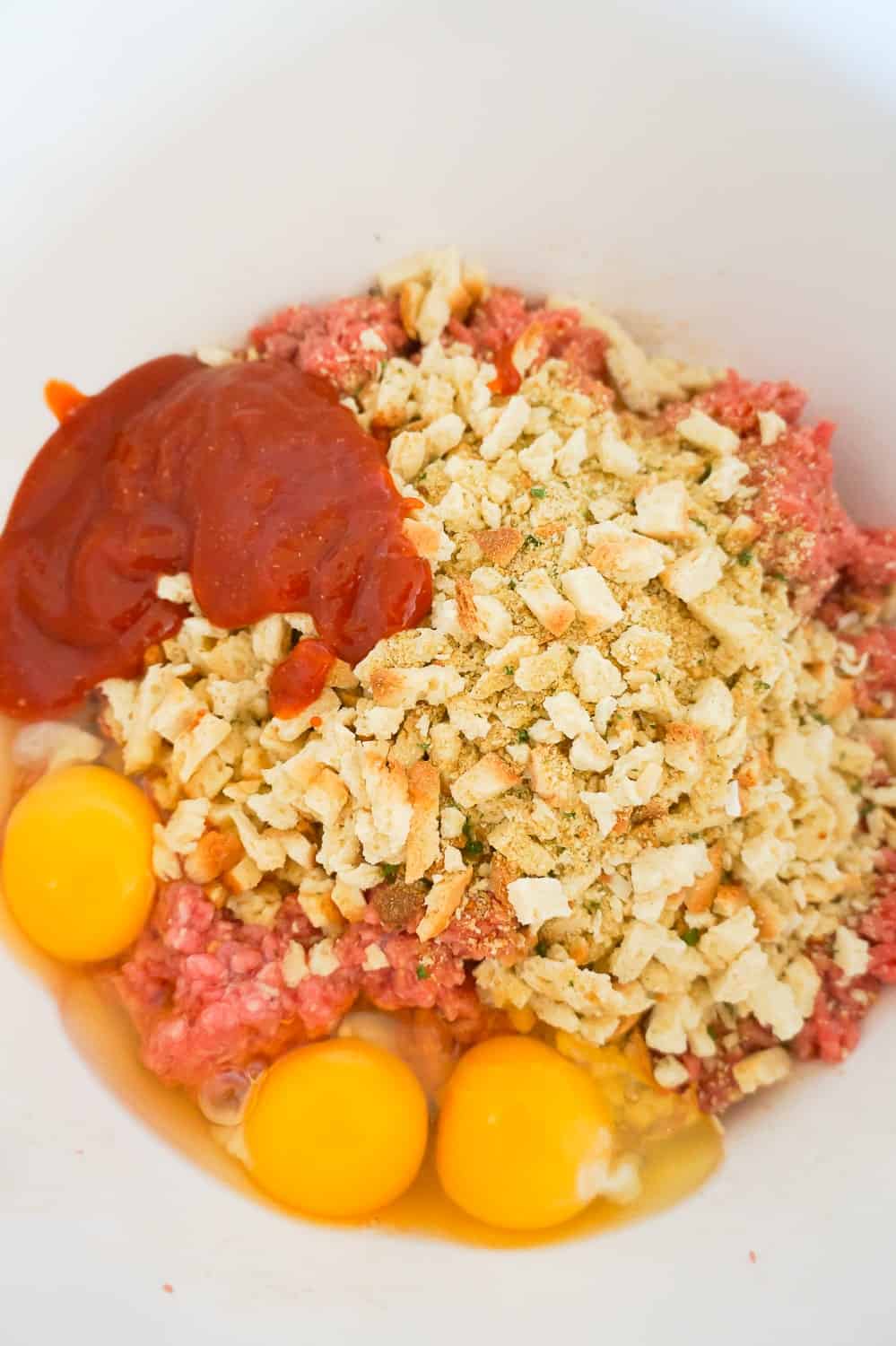 ground beef, Stove Top stuffing mix, eggs and sauce in a mixing bowl
