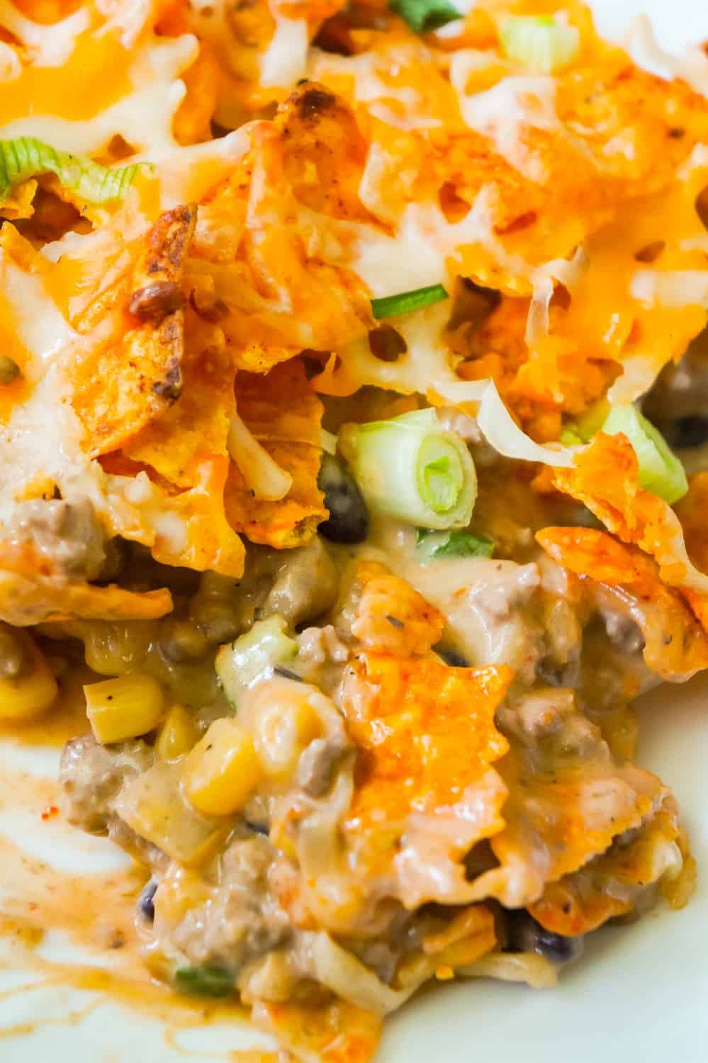 Doritos Casserole with Ground Beef is an easy dinner recipe the whole family will love. This hearty casserole is loaded with ground beef, cream cheese, corn, black beans, shredded cheese and topped with crumbled Doritos.