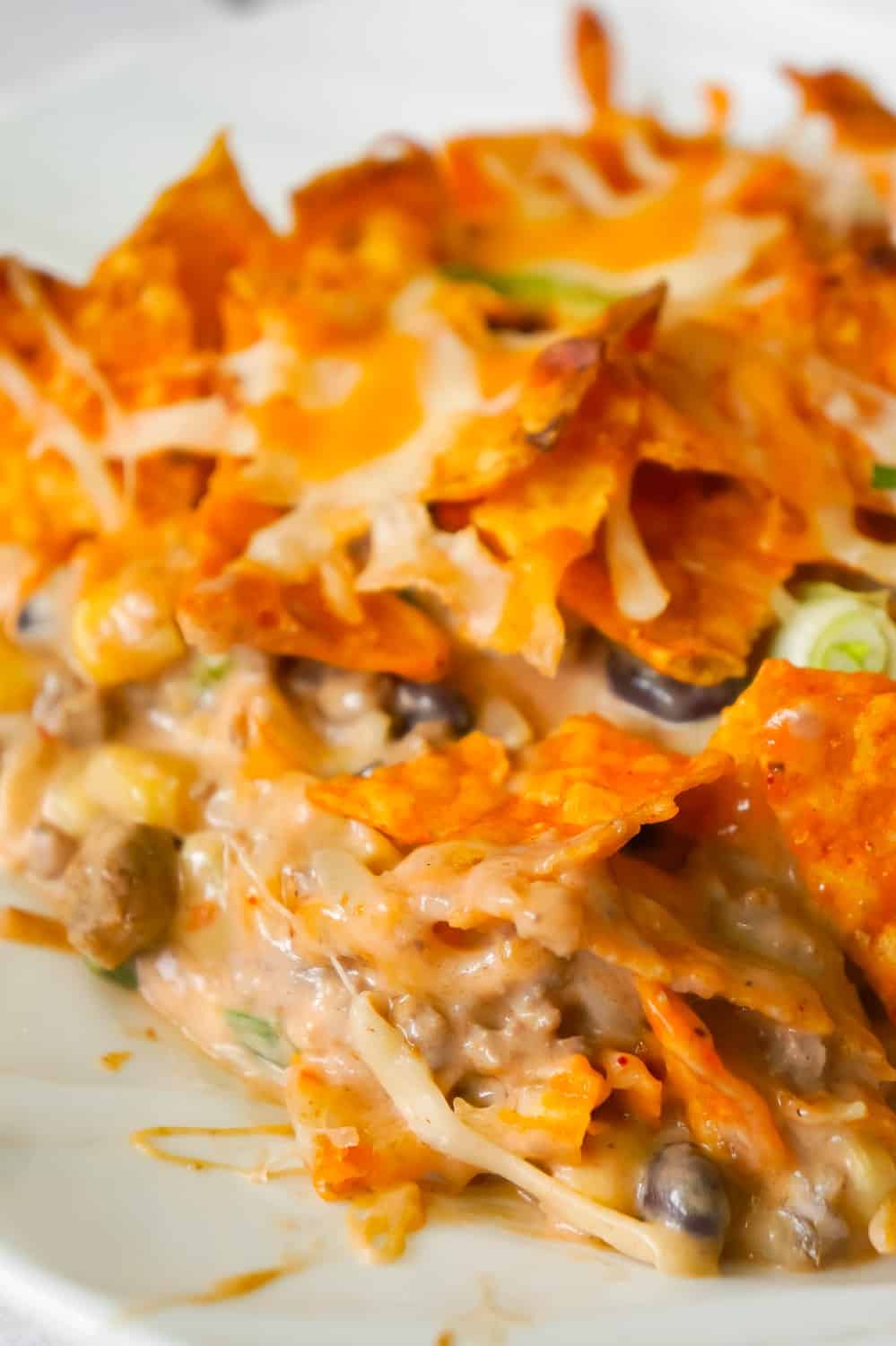 Doritos Casserole with Ground Beef is an easy dinner recipe the whole family will love. This hearty casserole is loaded with ground beef, cream cheese, corn, black beans, shredded cheese and topped with crumbled Doritos.