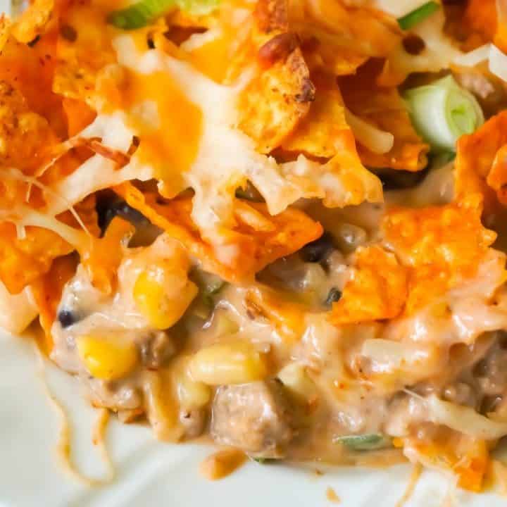 Doritos Casserole with Ground Beef is an easy dinner recipe the whole family will love. This hearty casserole is loaded with ground beef, cream cheese, corn, black beans, shredded cheese and topped with crumbled Doritos.