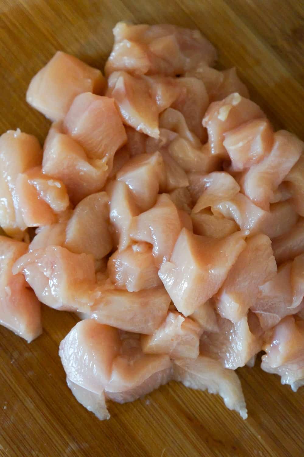 raw chicken breast chunks on a cutting board