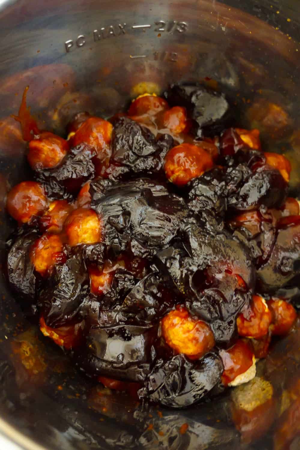 grape jelly and bbq sauce on top of frozen meatballs in an Instant Pot