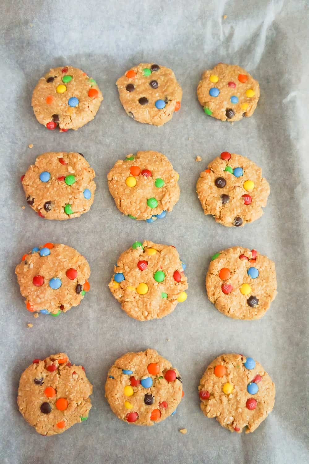 no bake peanut butter oatmeal cookies with M&M's on parchment paper