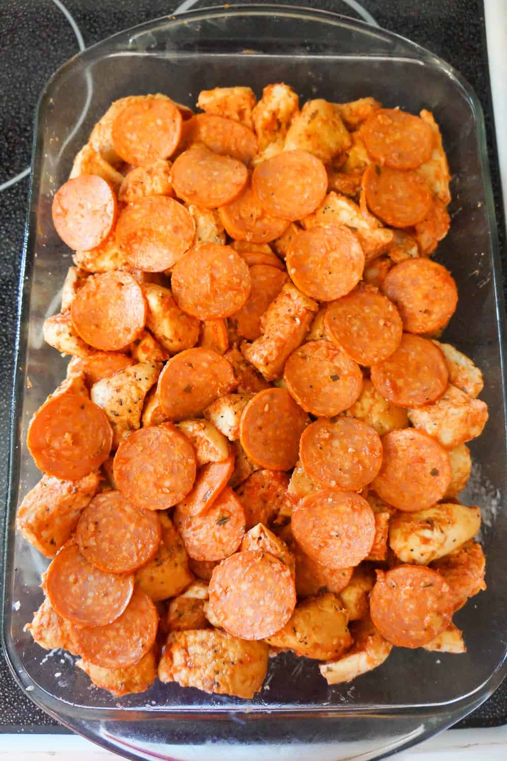 bagel pieces and pepperoni slices in a baking dish