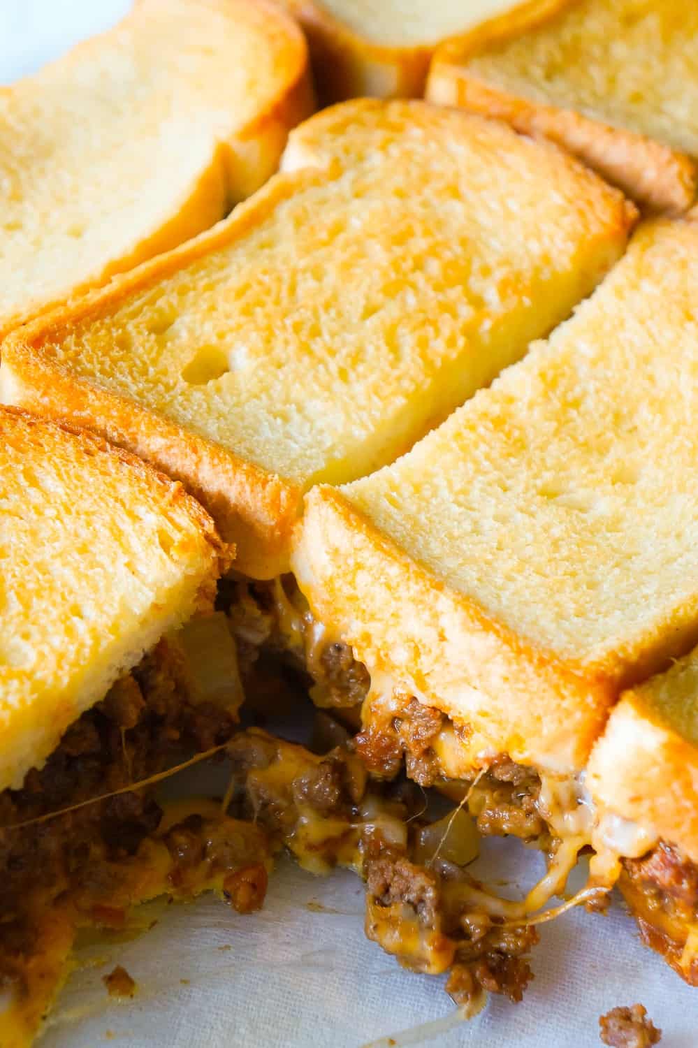 Bacon Cheeseburger Grilled Cheese Casserole is an easy dinner recipe the whole family will love. This delicious casserole is loaded with ground beef, bacon, onions and cheese sandwiched between layers of bread.