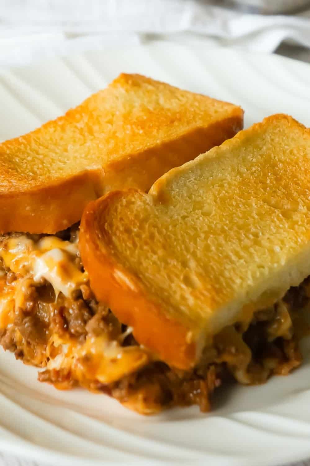 Bacon Cheeseburger Grilled Cheese Casserole is an easy dinner recipe the whole family will love. This delicious casserole is loaded with ground beef, bacon, onions and cheese sandwiched between layers of bread.