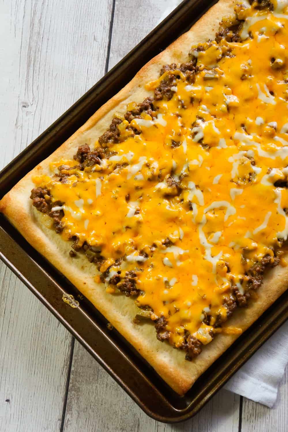 Big Mac Pizza is an easy ground beef dinner recipe that will please both kids and adults. This simple pizza is made with Pillsbury crust and loaded with ground beef, onions, dill pickles, cheddar cheese, homemade Big Mac sauce and shredded lettuce.