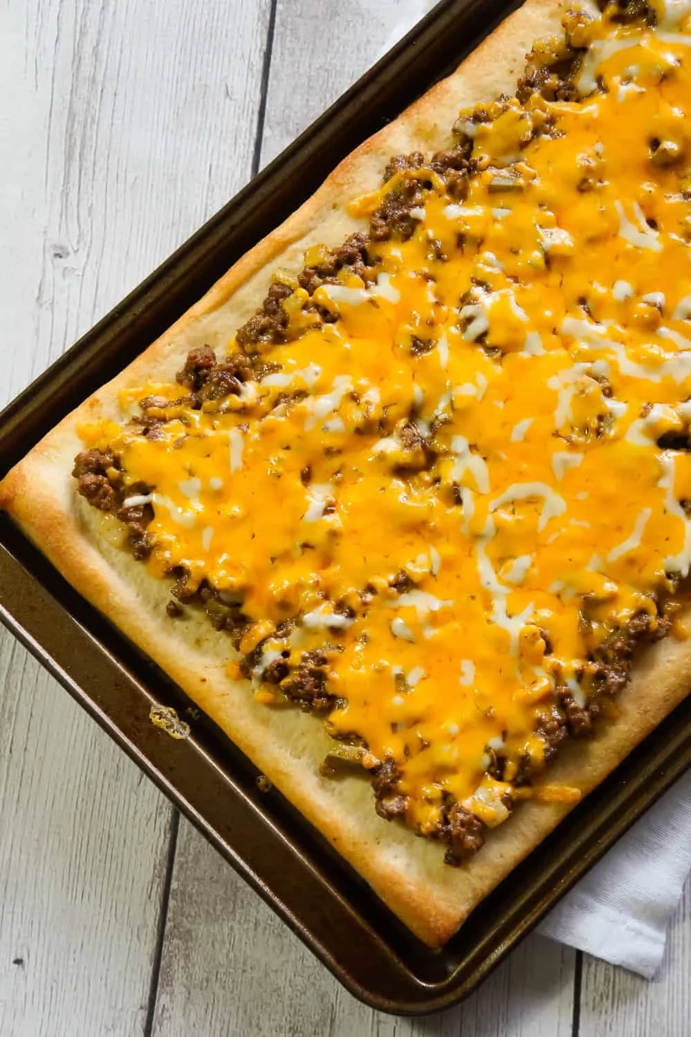 Big Mac Pizza is an easy ground beef dinner recipe that will please both kids and adults. This simple pizza is made with Pillsbury crust and loaded with ground beef, onions, dill pickles, cheddar cheese, homemade Big Mac sauce and shredded lettuce.