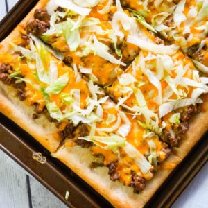 Big Mac Pizza is an easy ground beef dinner recipe that will please both kids and adults. This simple pizza is made with Pillsbury crust and loaded with ground beef, onions, dill pickles, cheddar cheese, homemade Big Mac sauce and shredded lettuce.