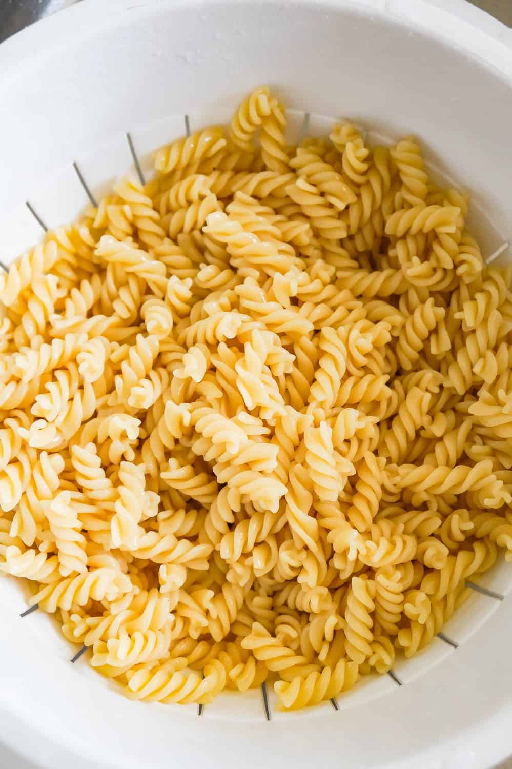 cooked fusilli noodles in a strainer