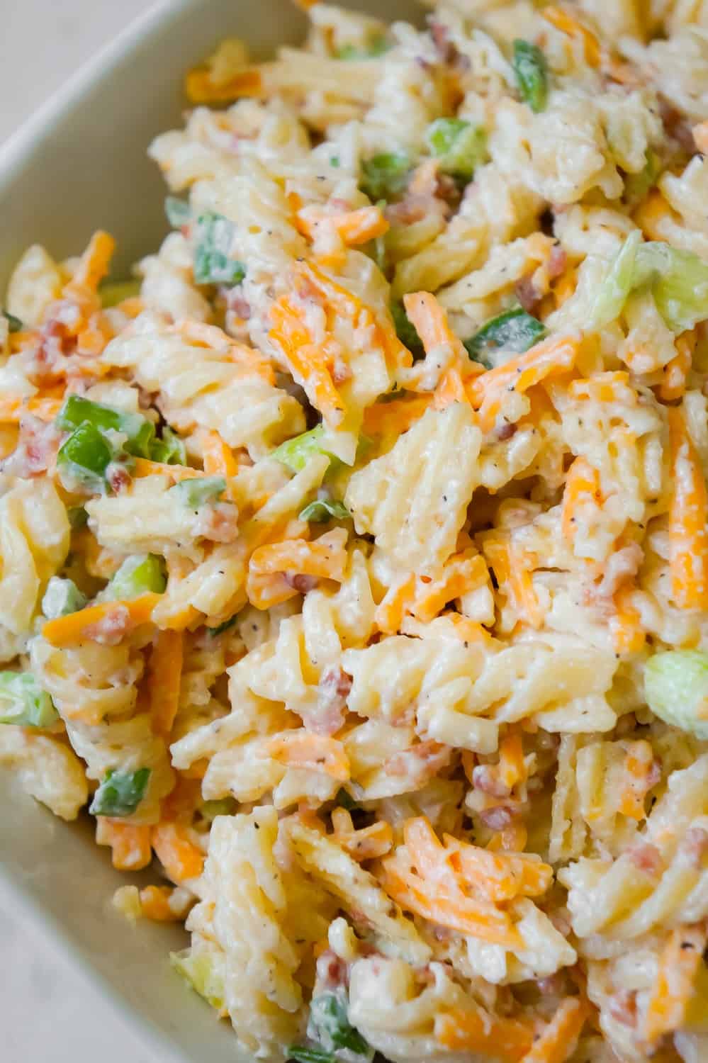 Cheddar Bacon Ranch Pasta Salad is a quick and easy cold side dish recipe perfect for summer. This creamy pasta salad is loaded with shredded cheddar cheese, bacon, green onions and crumbled potato chips.