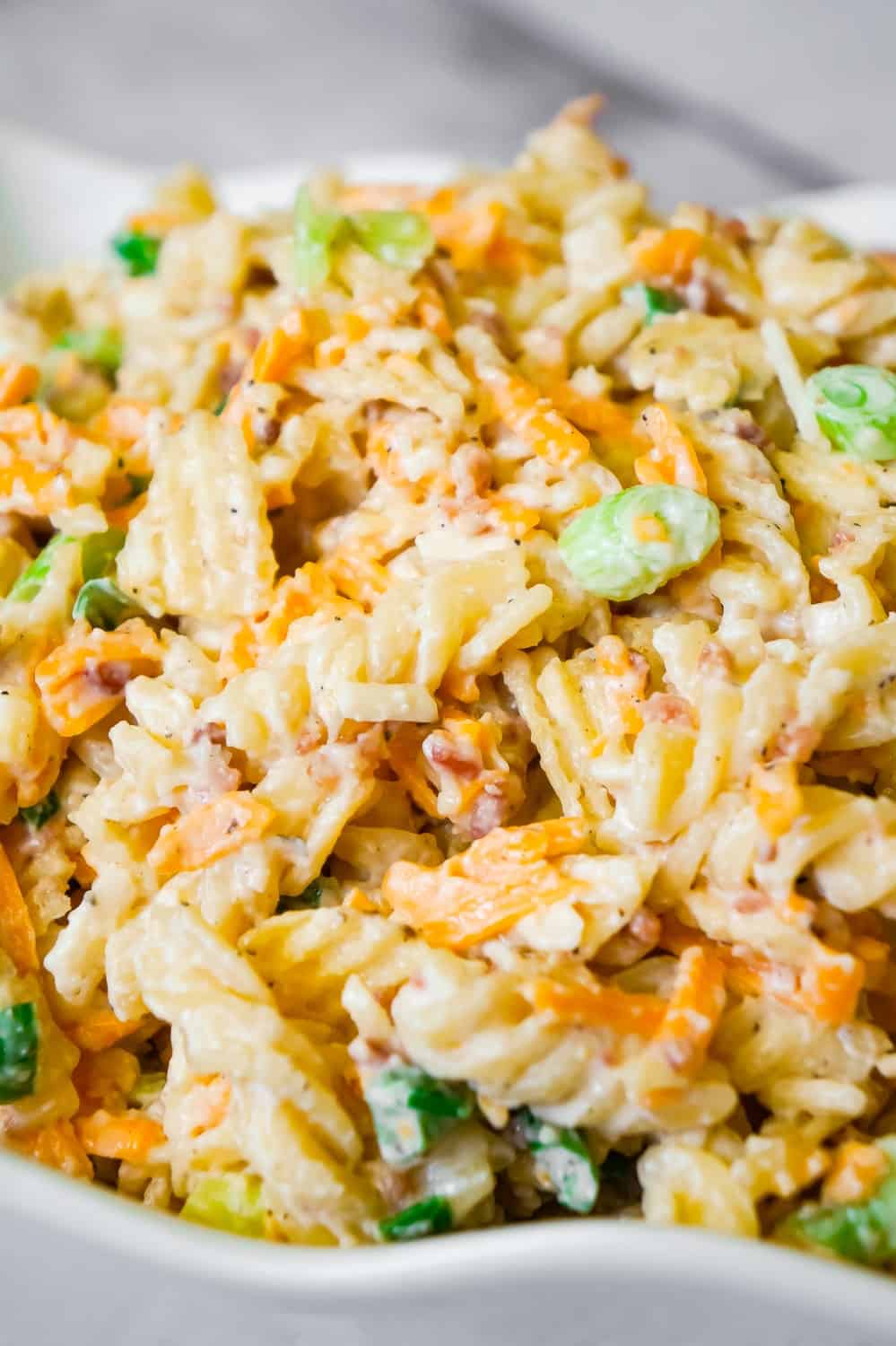 Cheddar Bacon Ranch Pasta Salad is a quick and easy cold side dish recipe perfect for summer. This creamy pasta salad is loaded with shredded cheddar cheese, bacon, green onions and crumbled potato chips.