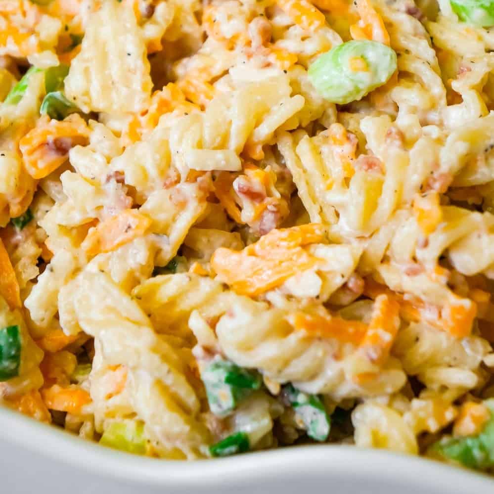 Cheddar Bacon Ranch Pasta Salad is a quick and easy cold side dish recipe perfect for summer. This creamy pasta salad is loaded with shredded cheddar cheese, bacon, green onions and crumbled potato chips.