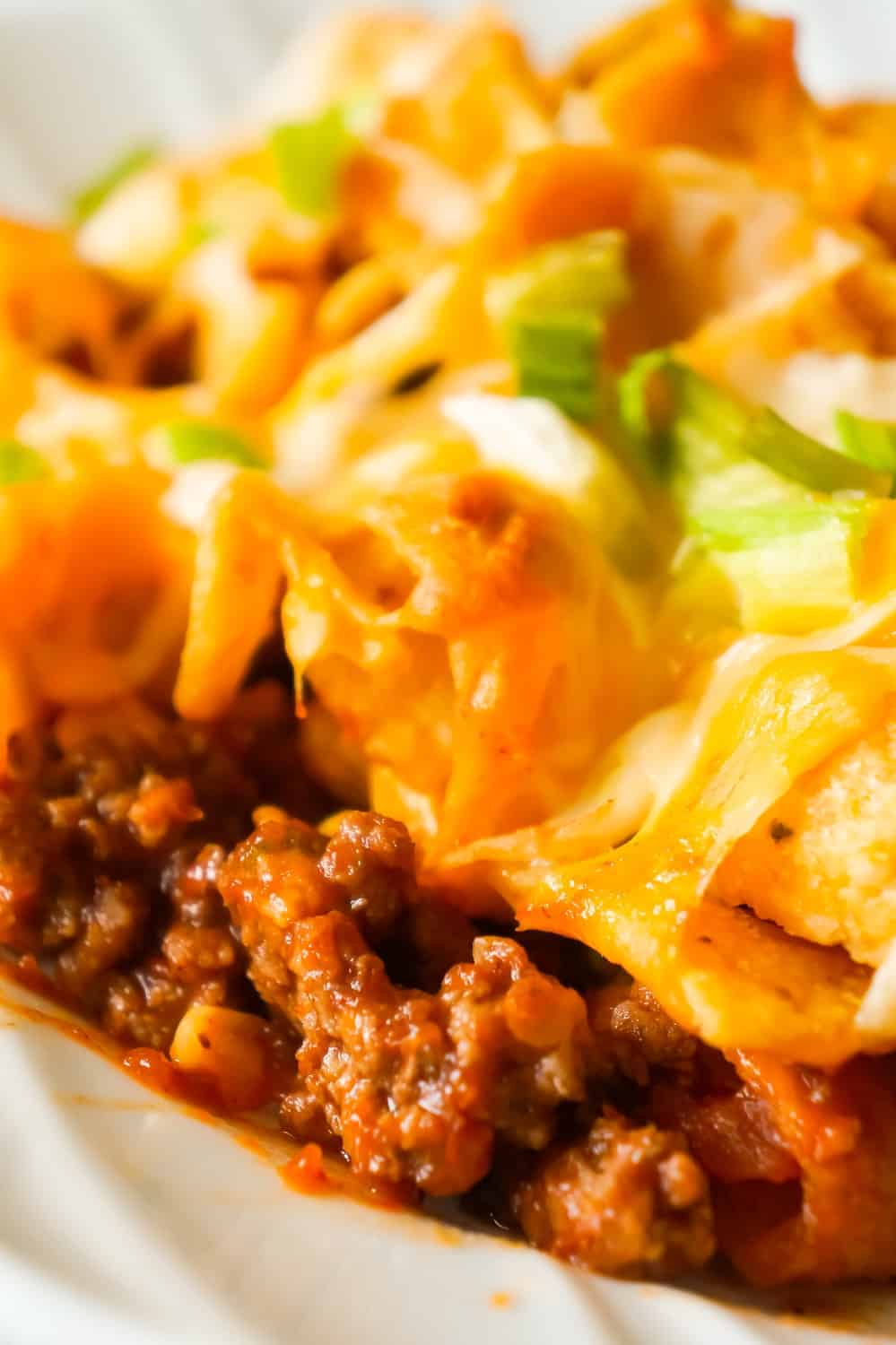 Frito Pie is an easy ground beef dinner recipe the whole family will love. This ground beef casserole starts with a chili base and is topped with Frito's corn chips, shredded cheese and green onions.