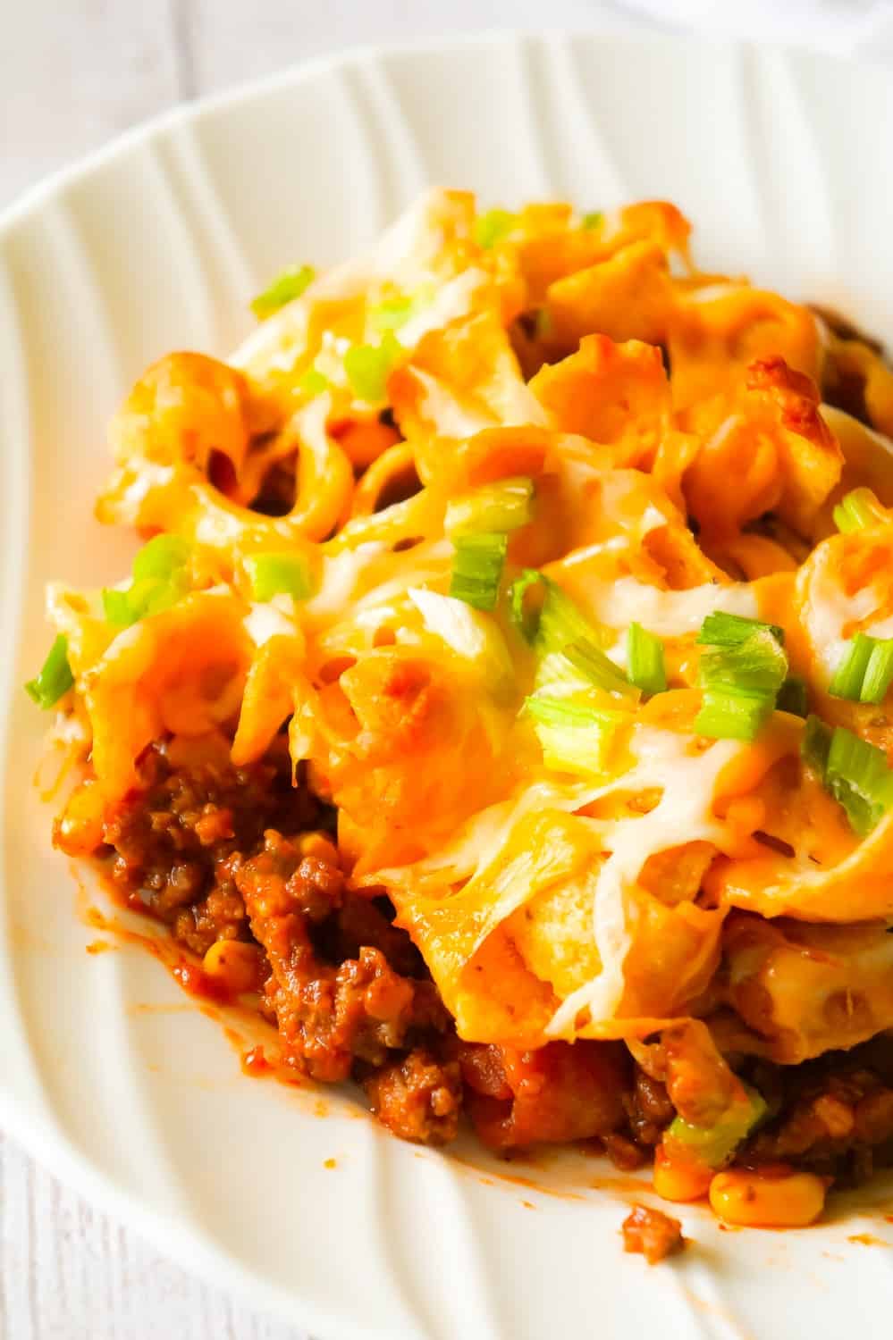 Frito Pie is an easy ground beef dinner recipe the whole family will love. This ground beef casserole starts with a chili base and is topped with Frito's corn chips, shredded cheese and green onions.