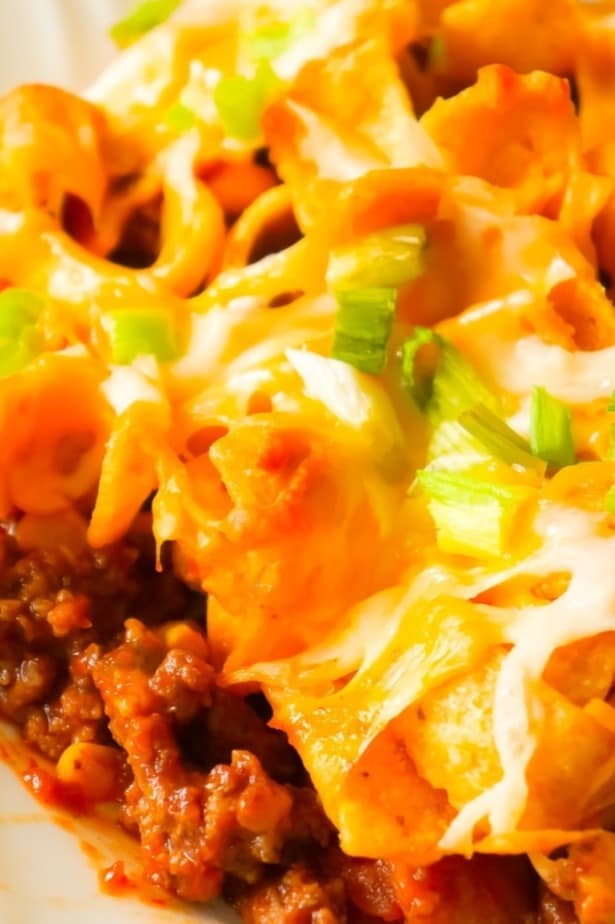Frito Pie is an easy ground beef dinner recipe the whole family will love. This ground beef casserole starts with a chili base and is topped with Frito's corn chips, shredded cheese and green onions.