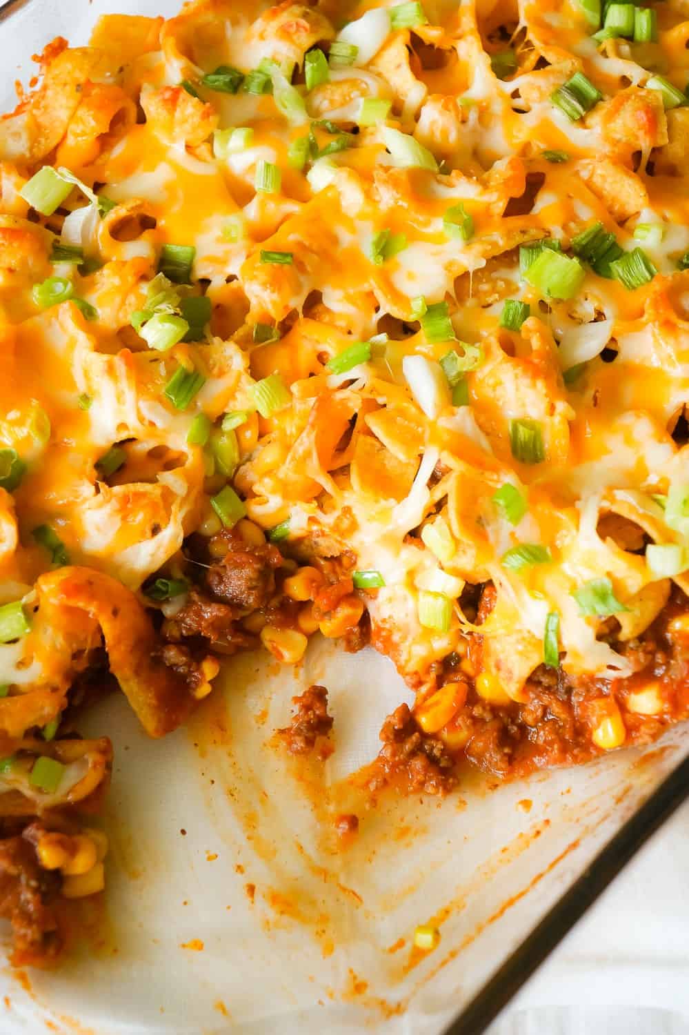 Frito Pie is an easy ground beef dinner recipe the whole family will love. This ground beef casserole starts with a chili base and is topped with Frito's corn chips, shredded cheese and green onions.