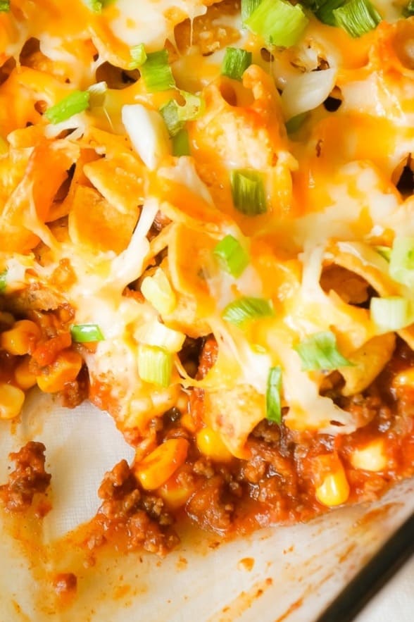 Frito Pie is an easy ground beef dinner recipe the whole family will love. This ground beef casserole starts with a chili base and is topped with Frito's corn chips, shredded cheese and green onions.