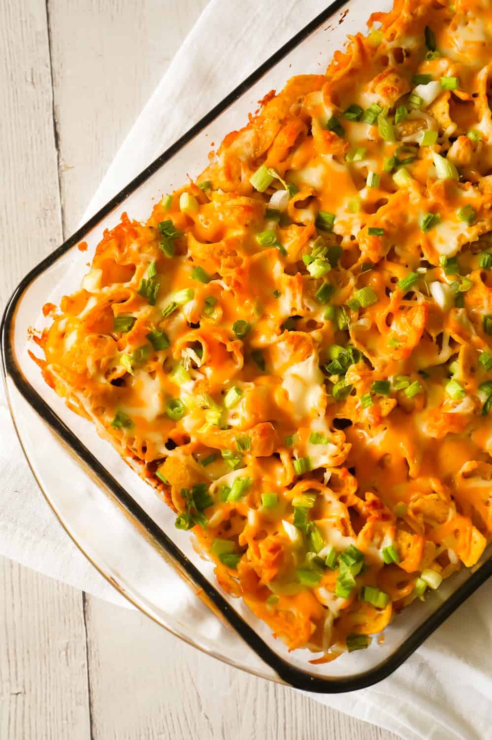 Frito Pie is an easy ground beef dinner recipe the whole family will love. This ground beef casserole starts with a chili base and is topped with Frito's corn chips, shredded cheese and green onions.