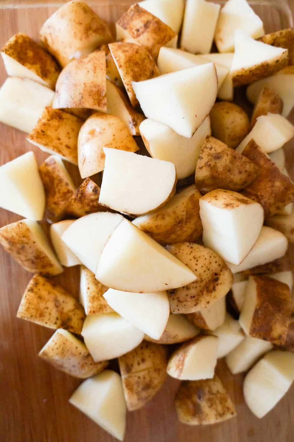 raw potato chunks on a cutting board