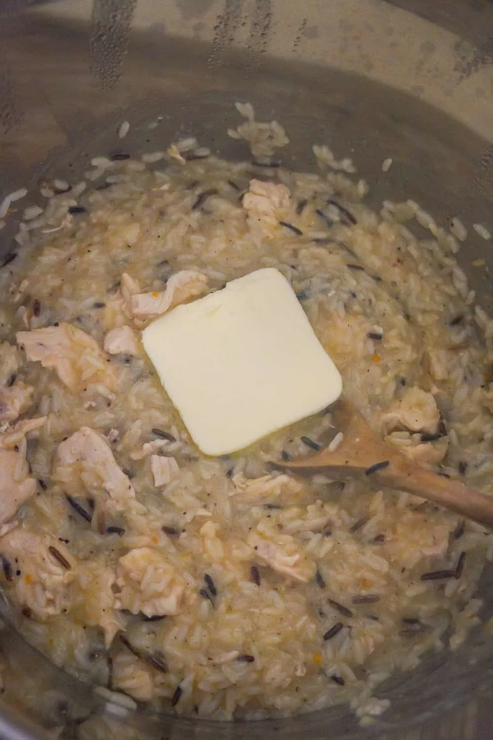 butter on top of chicken and rice in an Instant Pot