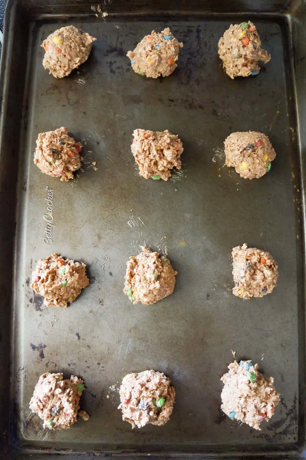 balls of chocolate monster cookie dough on a baking sheet