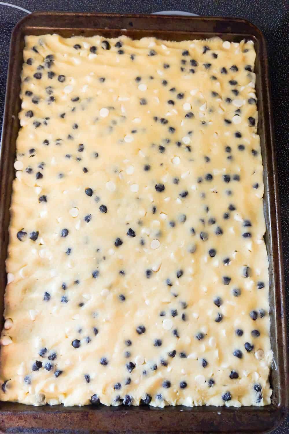 cookies and cream sugar cookie dough pressed onto a rectangular baking sheet