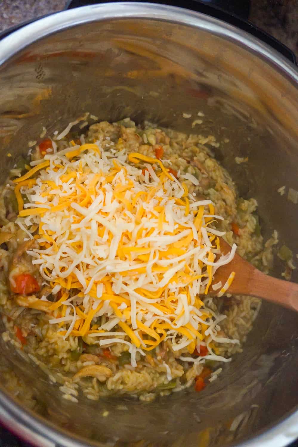 shredded mozzarella and cheddar on top of chicken and rice in an Instant Pot