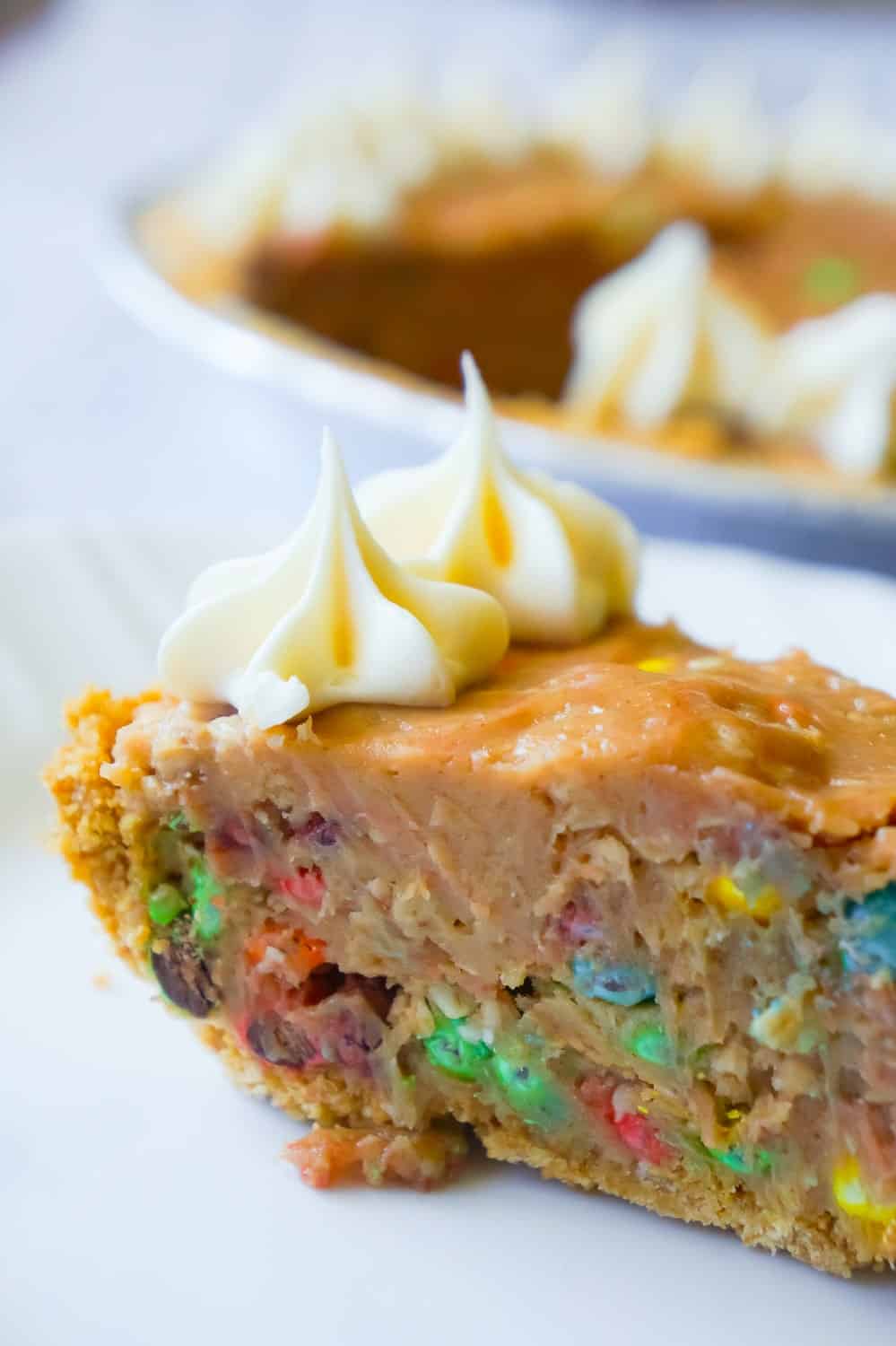 No Bake Monster Cookie Dough Cheesecake is a delicious dessert recipe with a graham cookie crust, filled with a monster cookie dough and cream cheese mixture and topped with cream cheese frosting.