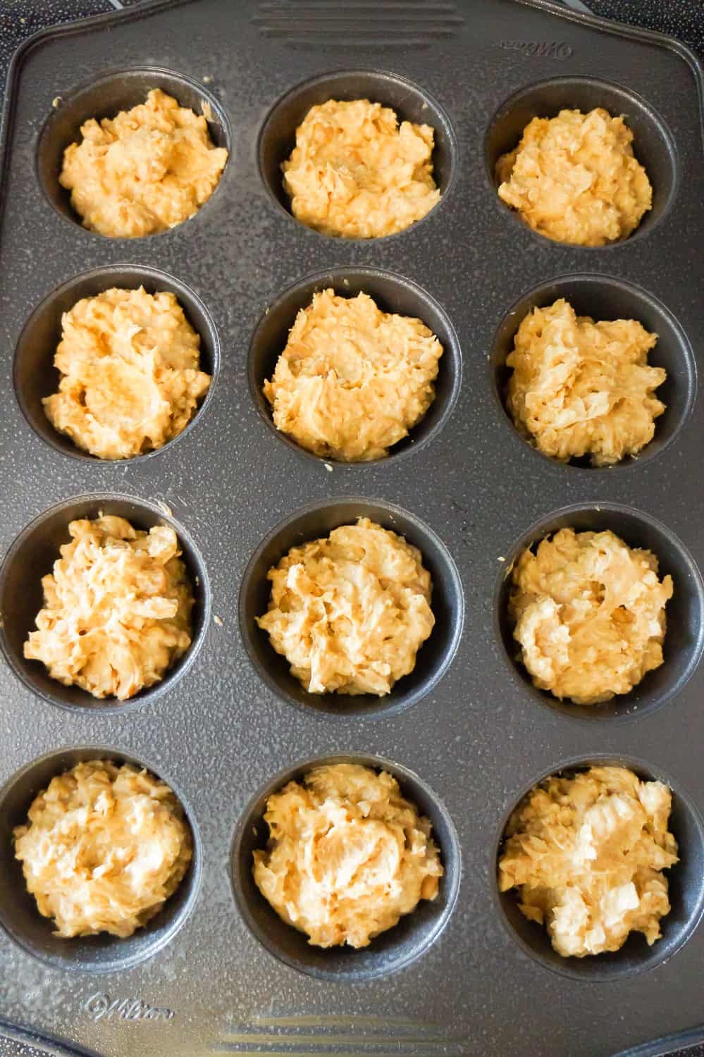 pumpkin spice peanut butter oatmeal muffin batter in muffin tins