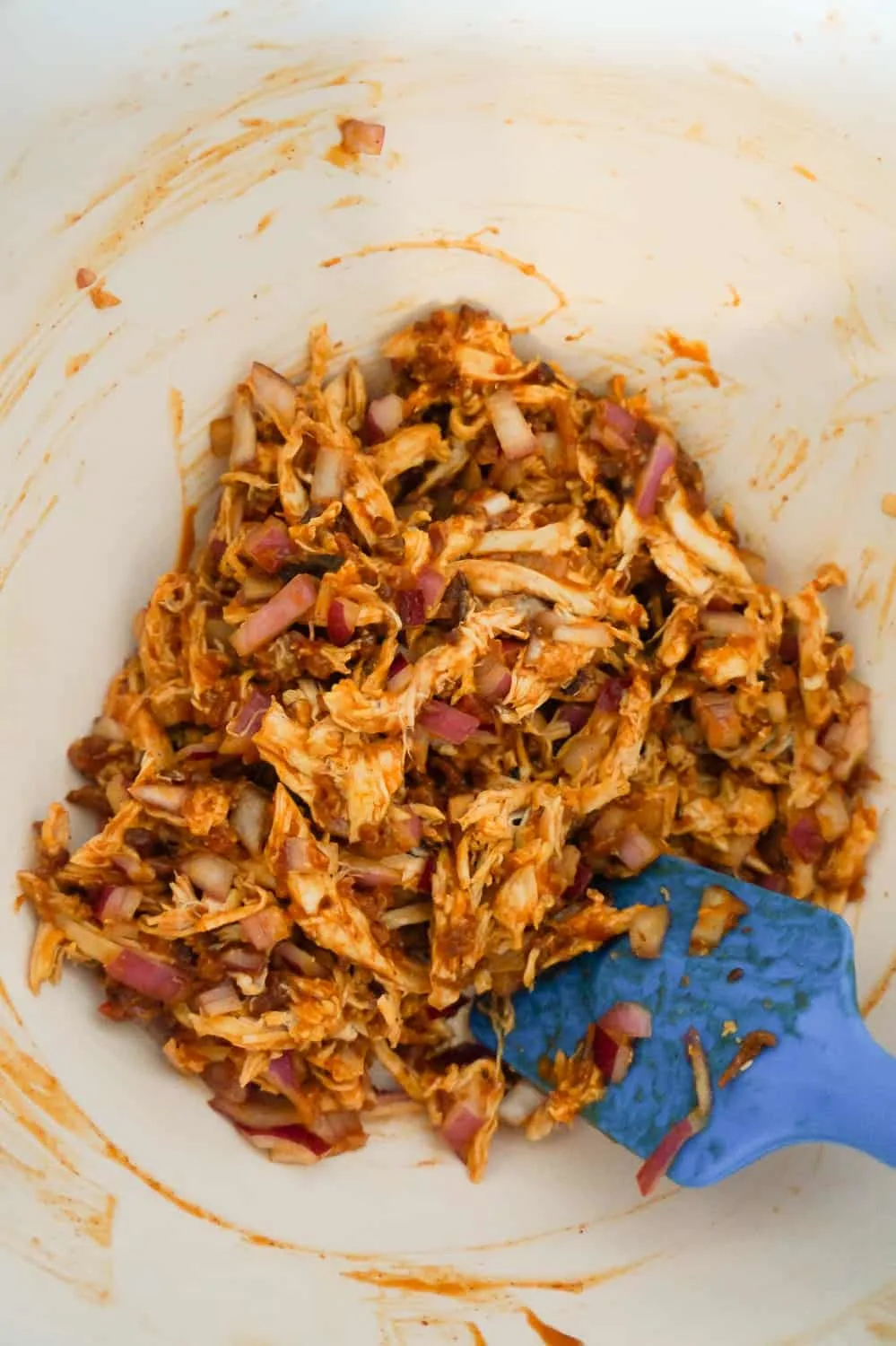 shredded chicken and BBQ sauce mixture in a mixing bowl