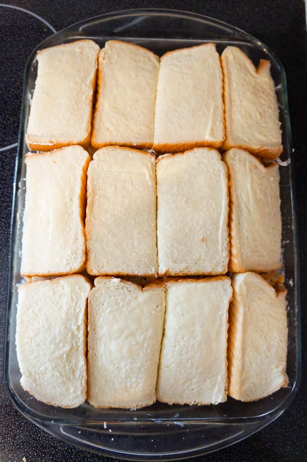 slices of bread on top of grilled cheese casserole before baking