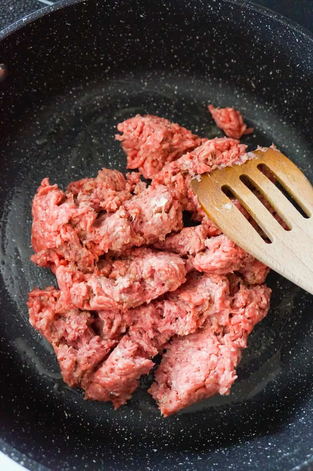 raw ground beef in a saute pan