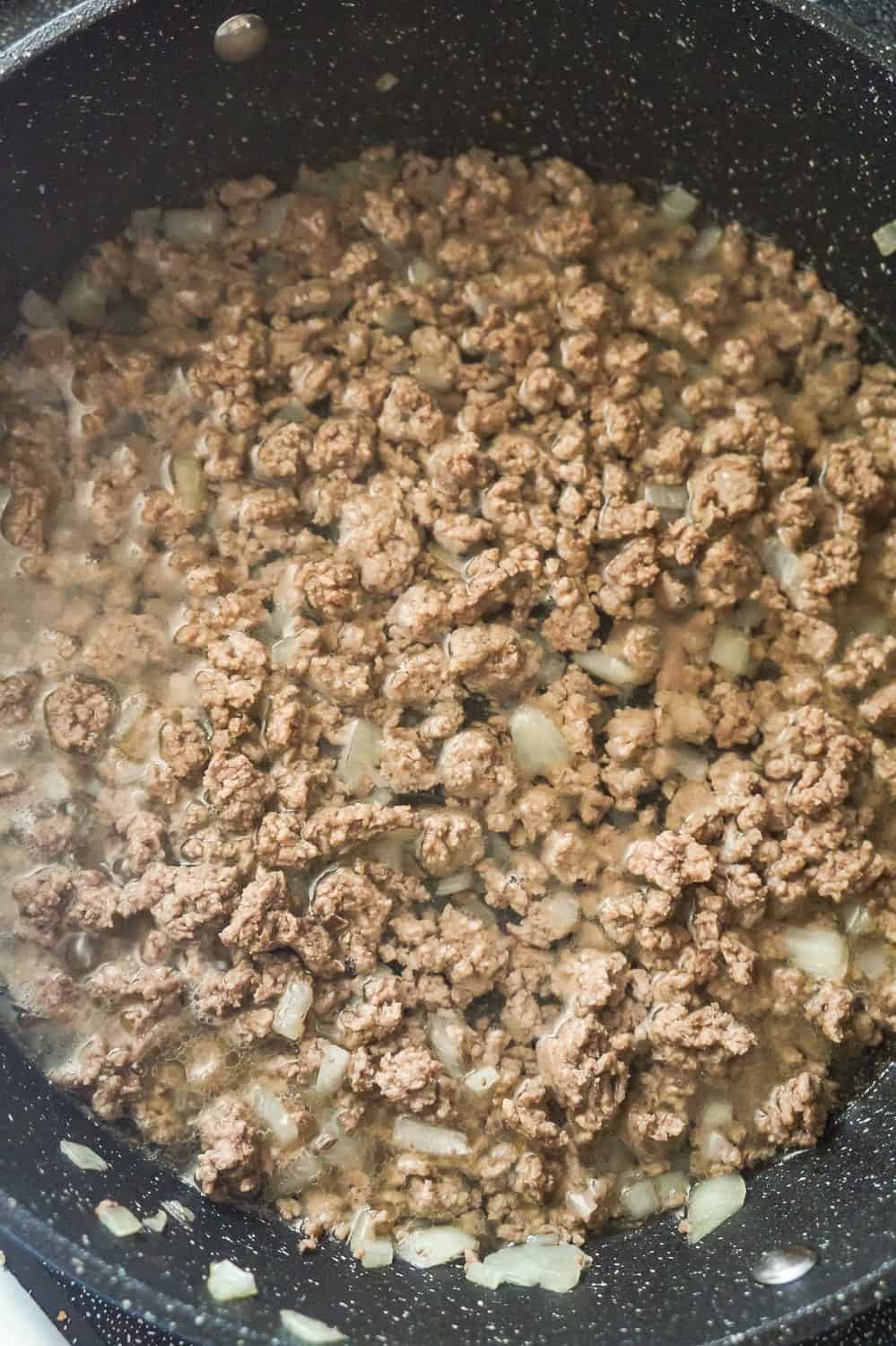 cooked ground beef in water in a saute pan