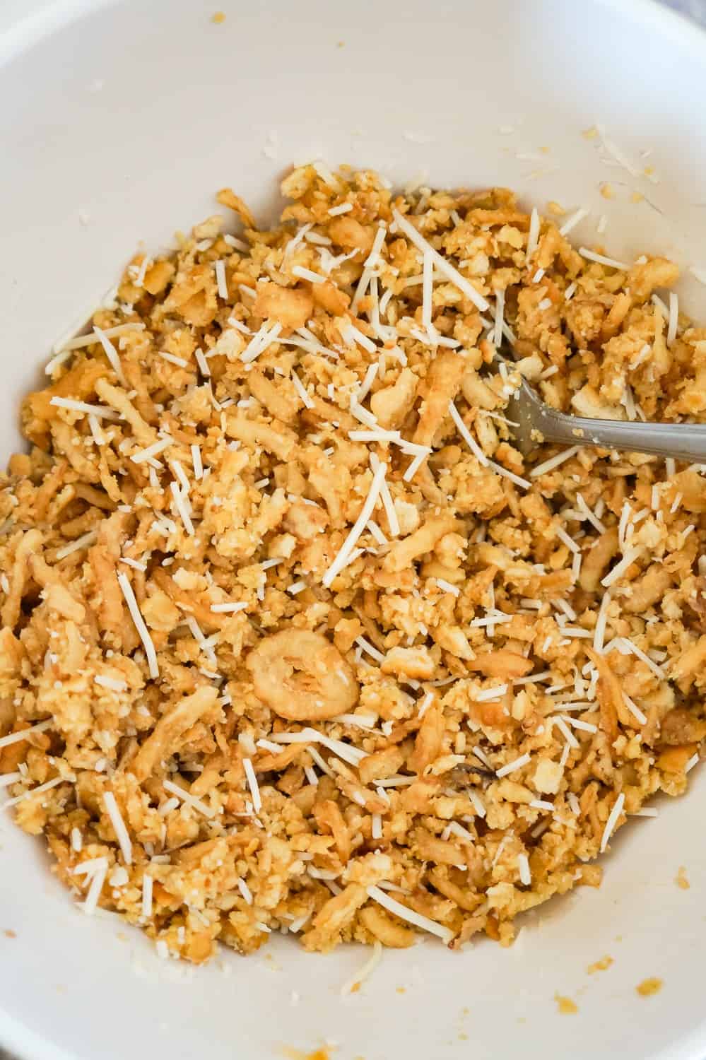 Ritz cracker, crispy fried onions and Parmesan cheese mixture in a mixing bowl