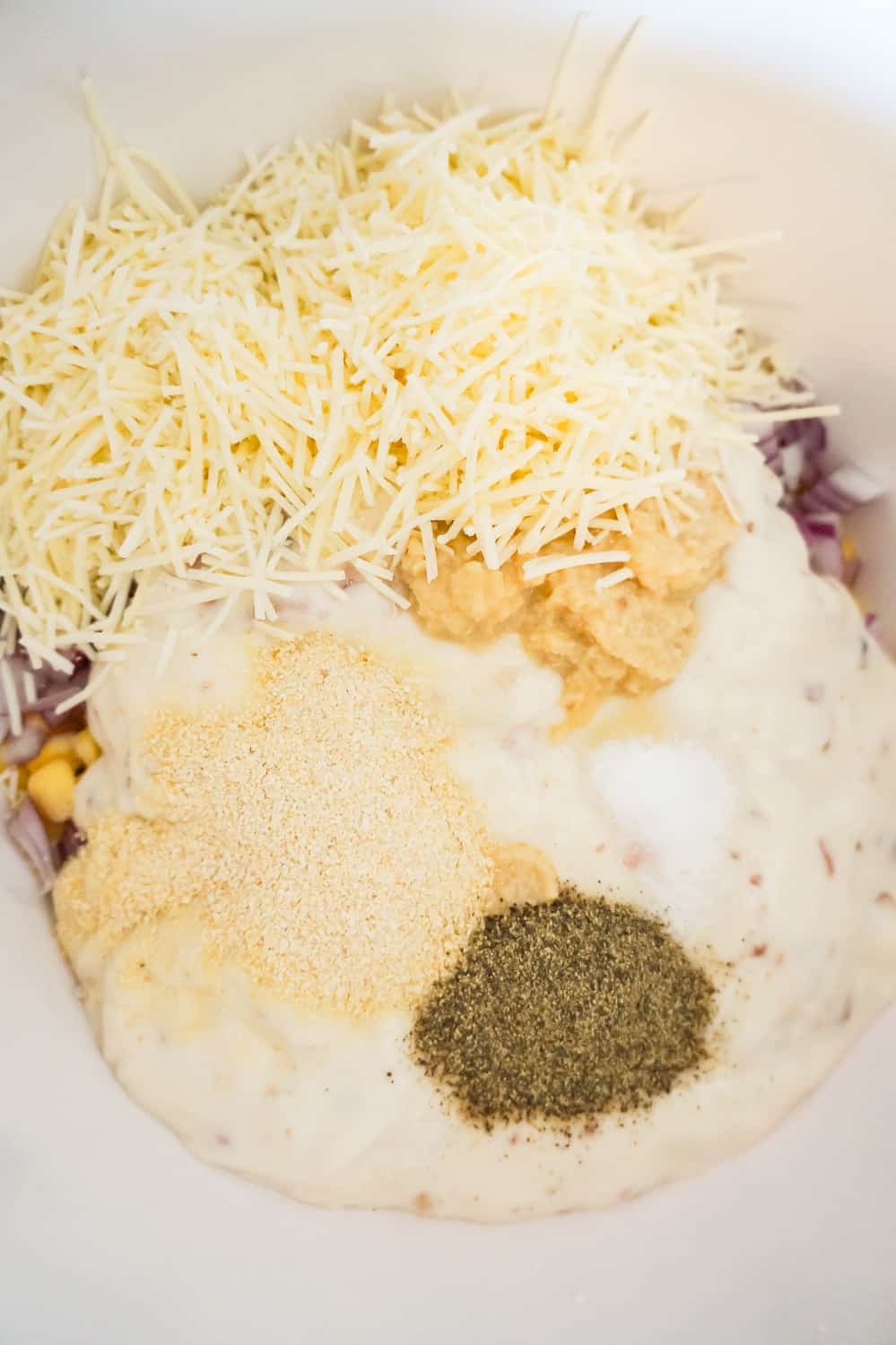 shredded Parmesan cheese, cream of bacon soup, garlic puree, salt and pepper in a mixing bowl