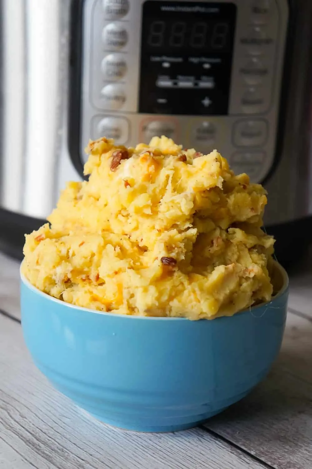 Instant Pot Cheesy Bacon Mashed Potatoes are a delicious pressure cooker side dish recipe using cream of bacon soup, crumbled bacon, cheddar and mozzarella cheese.
