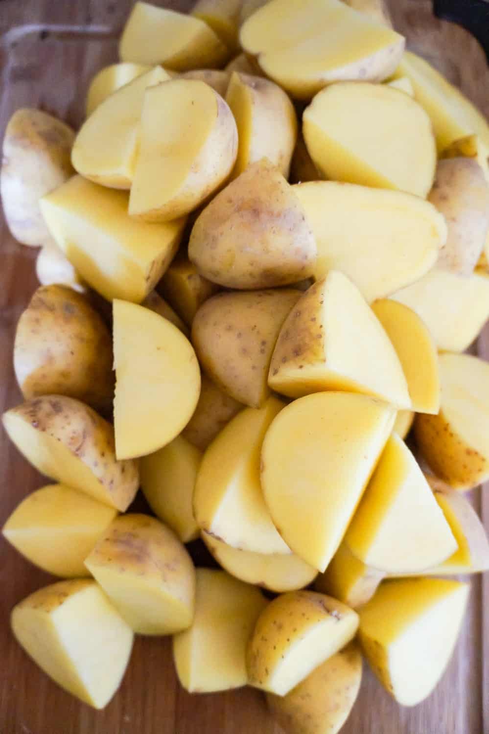 quartered potatoes on a cutting board