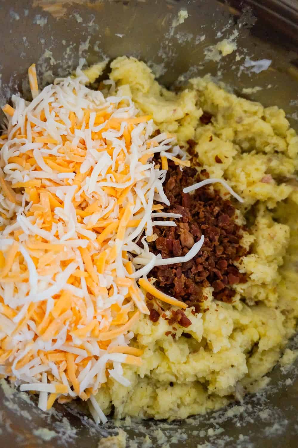 shredded cheddar, mozzarella and crumbled bacon on top of mashed potatoes in an Instant Pot