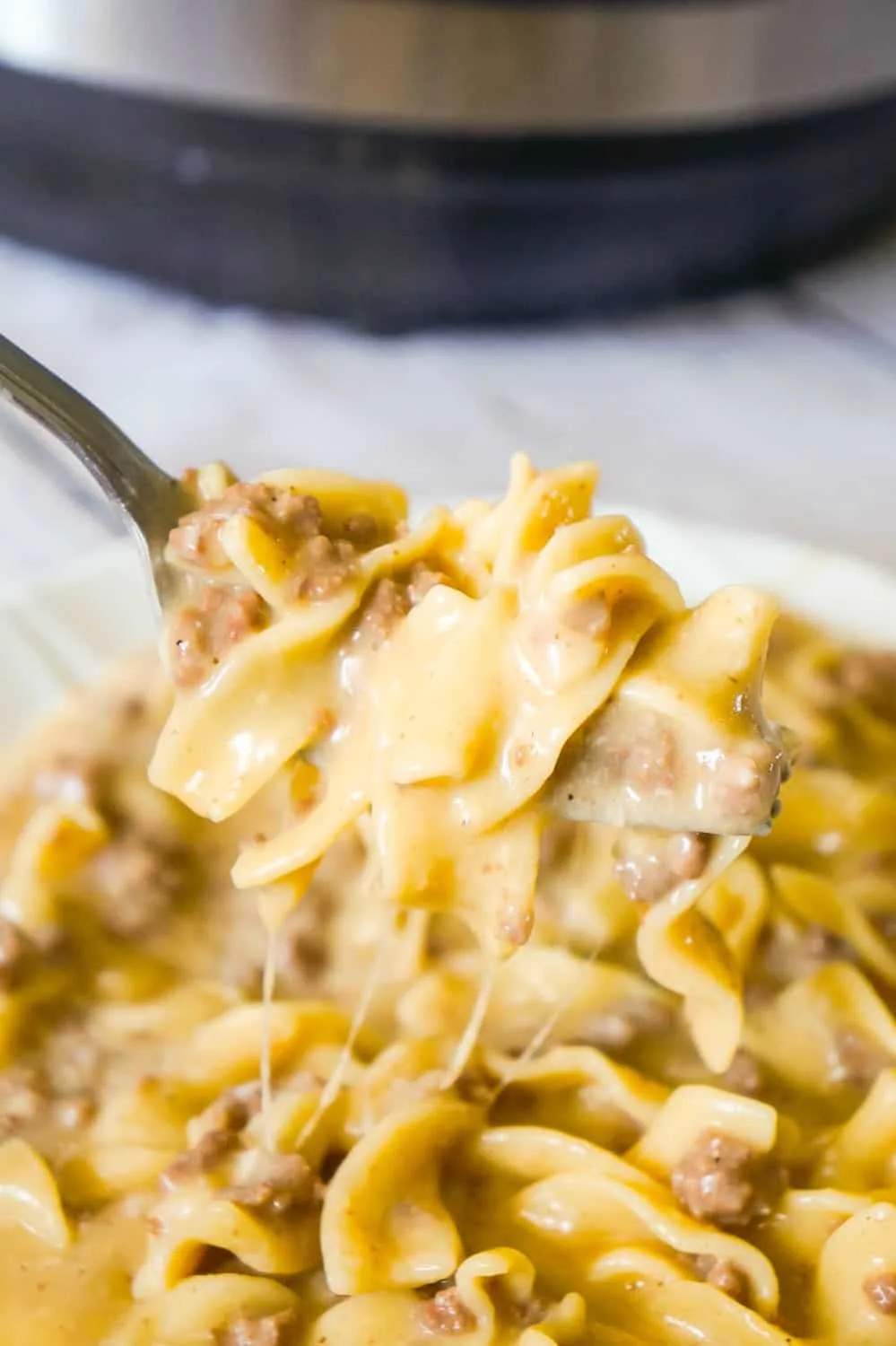 Instant Pot Cheesy Ground Beef and Noodles is an easy pressure cooker dinner recipe using hamburger meat and egg noodles loaded with mozzarella and cheddar cheese.