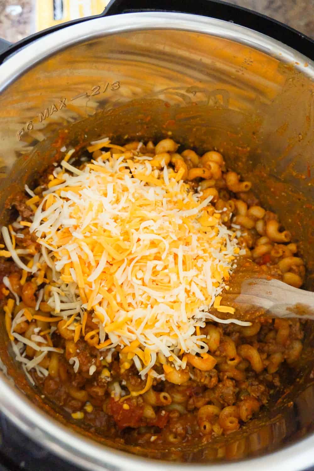 shredded mozzarella and cheddar cheese on top of pasta in an Instant Pot